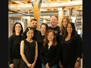 Group photo of nine diverse employees.