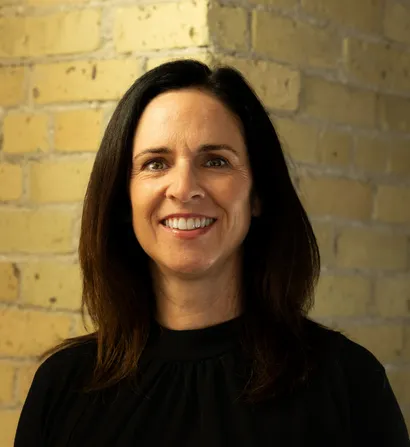 Smiling woman with dark hair, posing for a portrait.